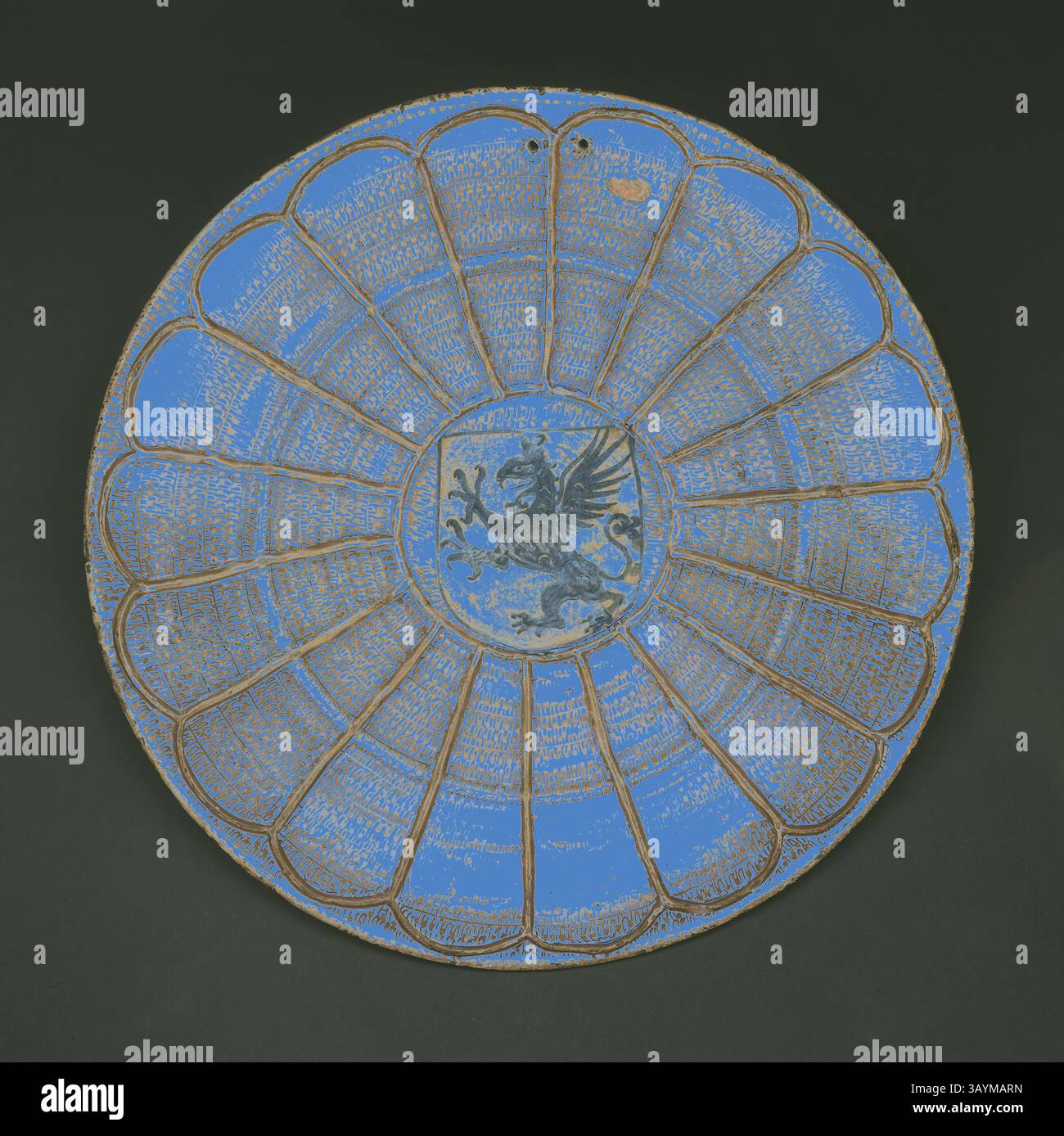Bouclier rond décoratif présentant un design complexe d'une créature mythique en son centre, entouré d'une série de panneaux rayonnants texturés. Les couleurs se mélangent harmonieusement, créant un impact visuel saisissant. Plaque de lusterware hispano-mauresque avec griffon, 1475/1500, Espagnol, Valencia (probablement Manises), Valencia, faïence émaillée étain avec lustre cuivre, diamètre : 44,8 cm (17 5/8 po.) Art classique avec une touche moderne réinventé par Artotop Banque D'Images