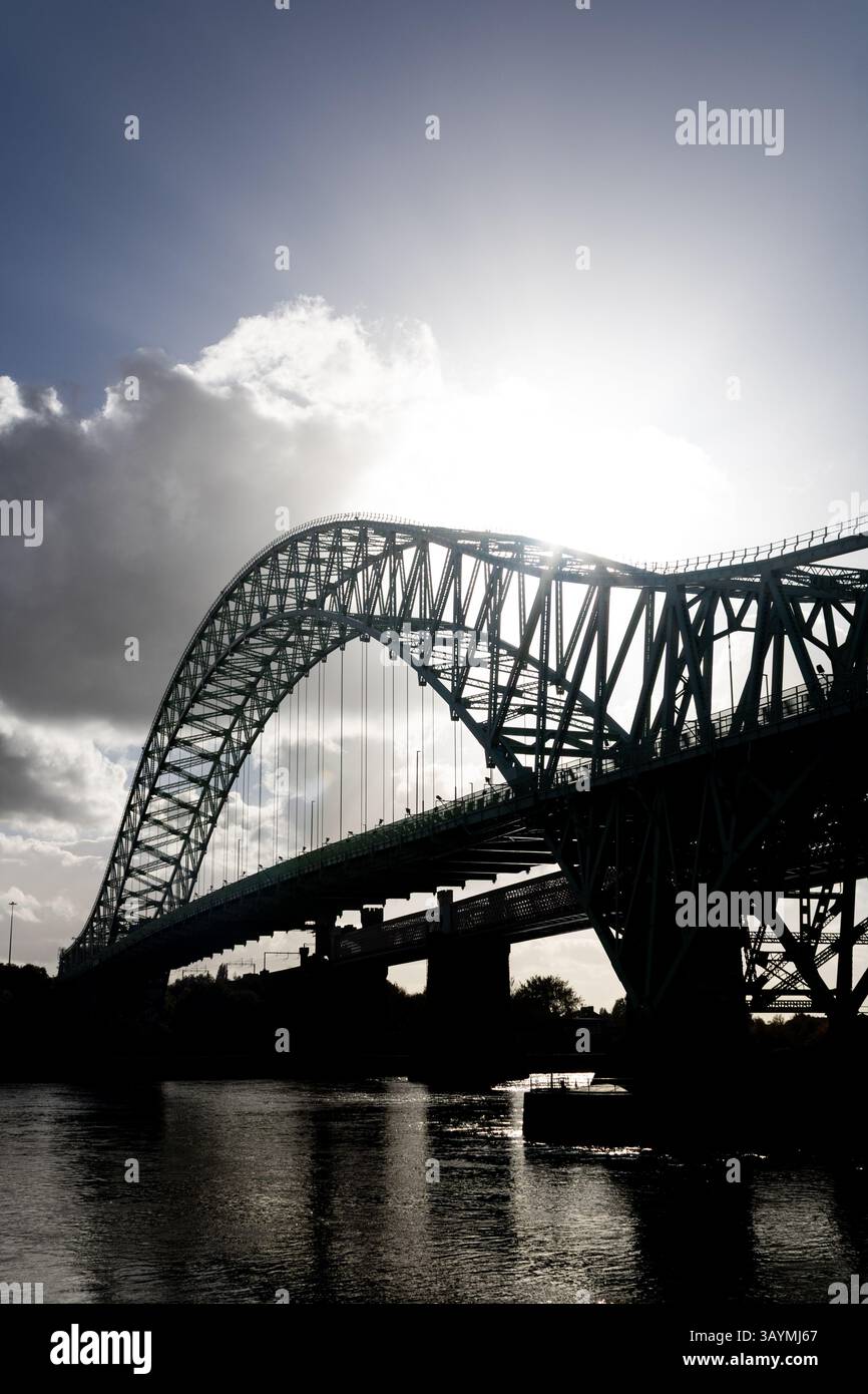 Pont Runcorn avec soleil bas derrière l'arche Banque D'Images