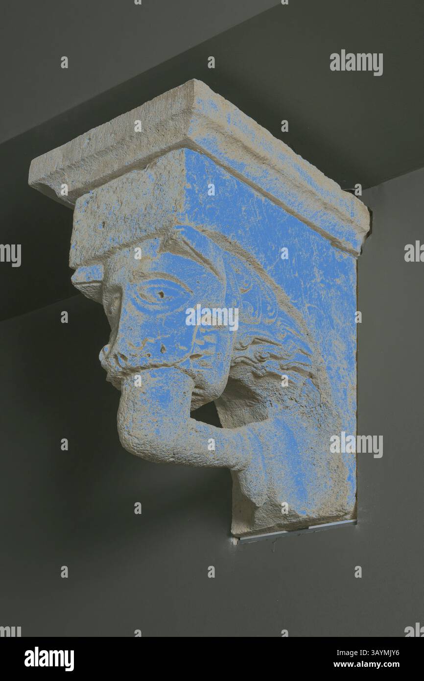 Un élément architectural décoratif représentant le visage stylisé d'une créature mythique, mettant en valeur des détails complexes et un accent de couleur frappant. Corbeau avec masque animal avec dents attachées sur la jambe humaine de l'église du monastère de notre-Dame-de-la-Grande-sauve, 1150/1200, Français, Aquitaine, calcaire, 45,7 × 31,8 × 59,7 cm (18 × 12 1/2 × 23 1/2 po) Art classique avec une touche moderne réinventé par Artotop Banque D'Images