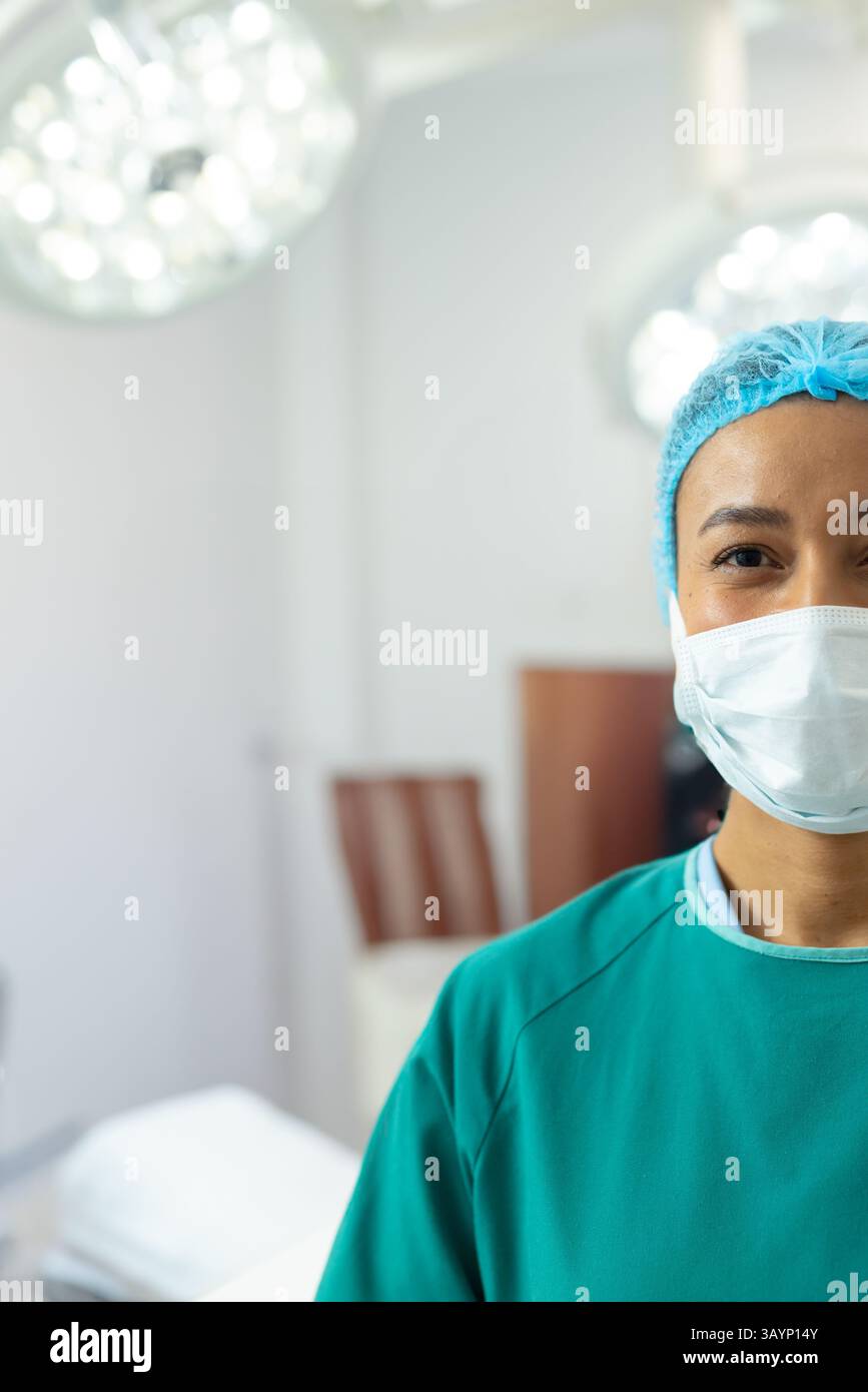 Femme afro-américaine portant une casquette chirurgicale, un masque et des gommages verts dans OU avec des lumières, copiez l'espace Banque D'Images