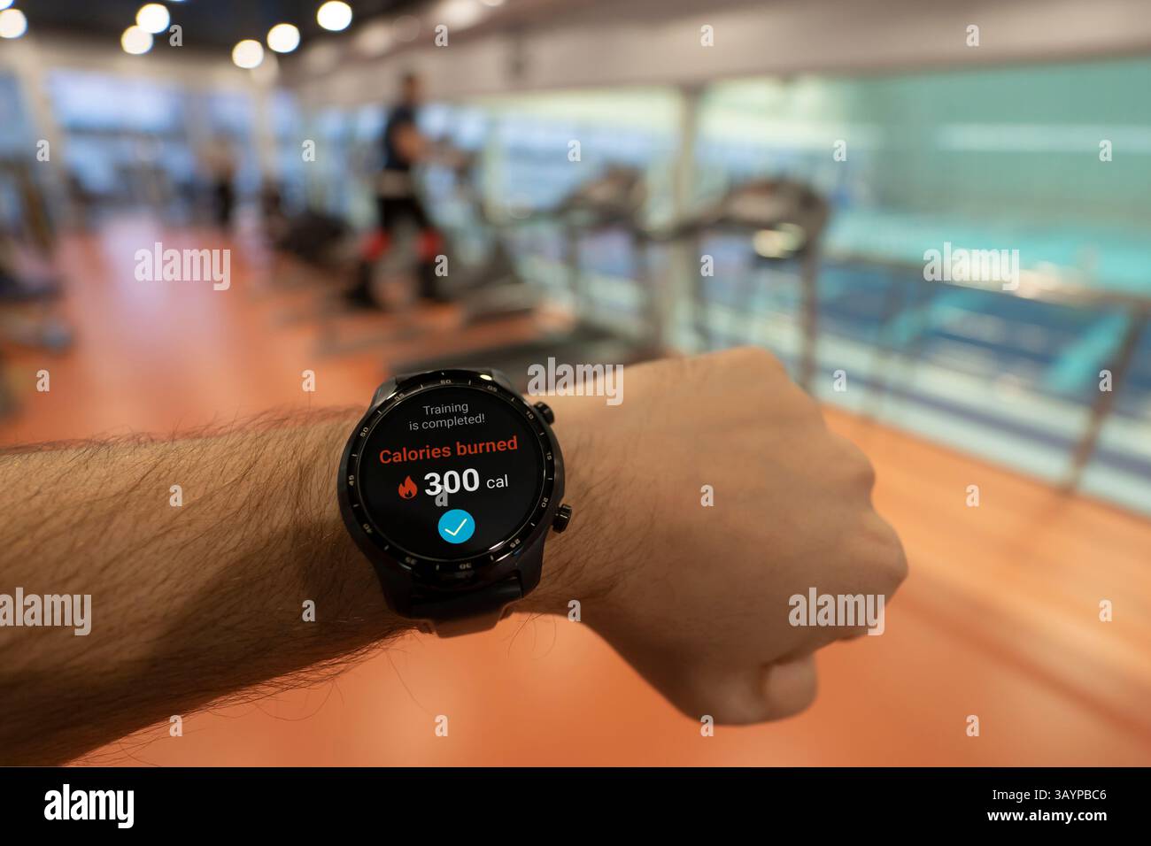 Un homme au stade vérifie le nombre de calories brûlées dans sa montre intelligente. Exercice quotidien dans l'air frais pour la perte de poids. Gadgets intelligents pour le sport Banque D'Images