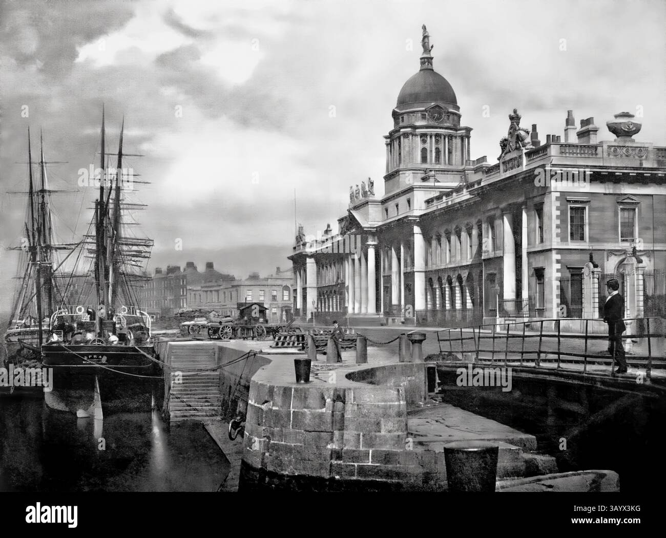 Une vue de la fin du XIXe siècle de navires amarrés le long de la maison de douane néoclassique du XVIIIe siècle sur la rivière Liffey, Dublin, Irlande. La construction a commencé en 1781 et James Gandon a été nommé architecte, après la mort de Thomas Cooley, l'architecte original du projet. Une fois achevé et ouvert aux entreprises le 7 novembre 1791, il avait coûté £200 000 à construire – une somme considérable à l’époque. Les quatre façades du bâtiment sont décorées d'armoiries et de sculptures ornementales (d'Edward Smyth) représentant les rivières irlandaises. Banque D'Images