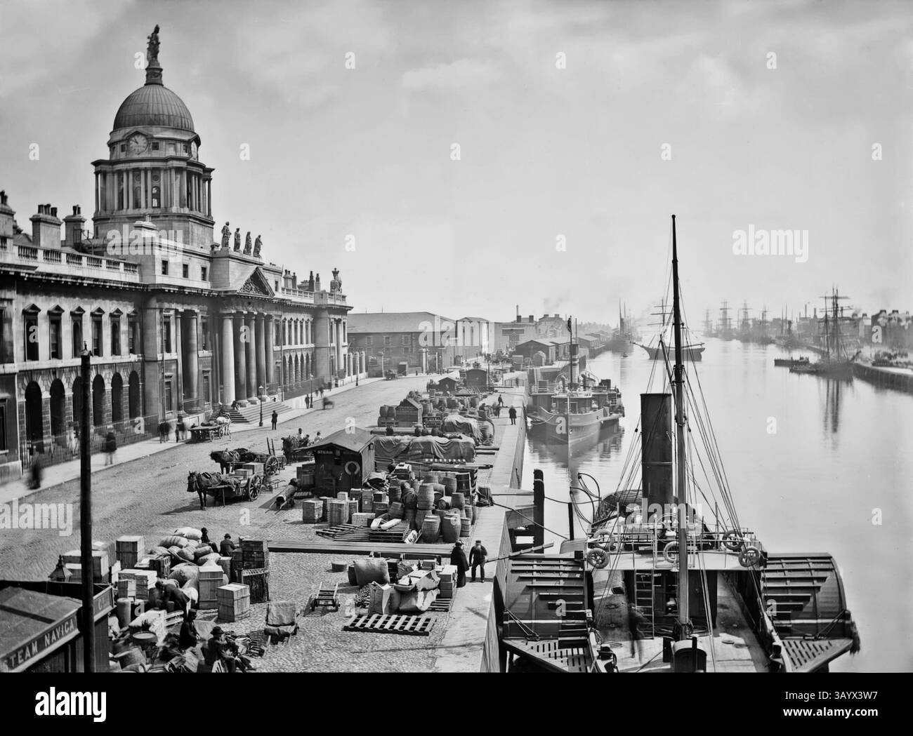 Une vue du début du XXe siècle de navires amarrés le long de la maison de douane néoclassique du XVIIIe siècle sur la rivière Liffey, Dublin, Irlande. La construction a commencé en 1781 et James Gandon a été nommé architecte, après la mort de Thomas Cooley, l'architecte original du projet. Une fois achevé et ouvert aux entreprises le 7 novembre 1791, il avait coûté £200 000 à construire – une somme considérable à l’époque. Les quatre façades du bâtiment sont décorées d'armoiries et de sculptures ornementales (d'Edward Smyth) représentant les rivières irlandaises. Banque D'Images
