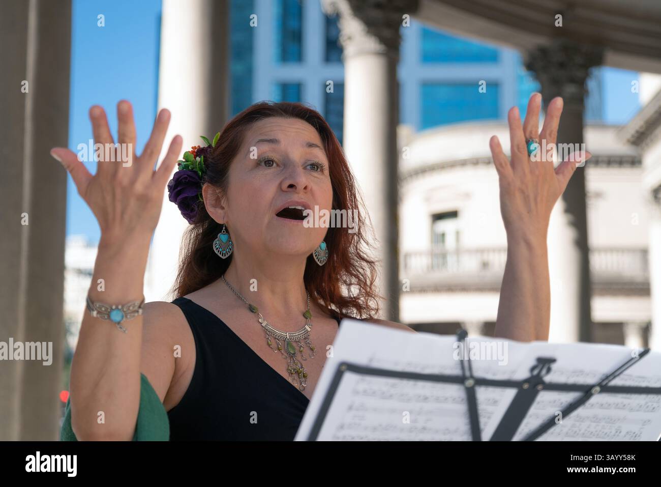 Chanteuse d'opéra jouant à l'extérieur, chantant avec émotion et utilisant des partitions Banque D'Images