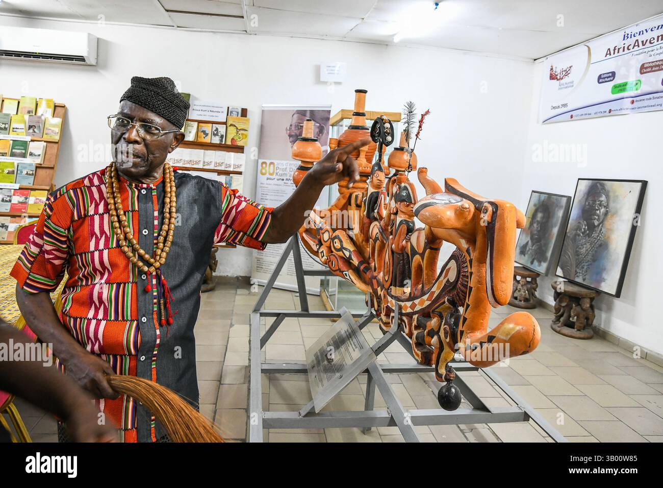 Douala, Cameroun. 17 mars 2025. Alexandre Kum'a Ndumbe Ill, prince camerounais, historien et professeur émérite dans plusieurs universités, présente des objets d'art traditionnel à son bureau de Douala, Cameroun, le 17 mars 2025. POUR ALLER AVEC 'Feature : prince camerounais brandit la plume comme épée pour la renaissance africaine' crédit : Kepseu/Xinhua/Alamy Live News Banque D'Images