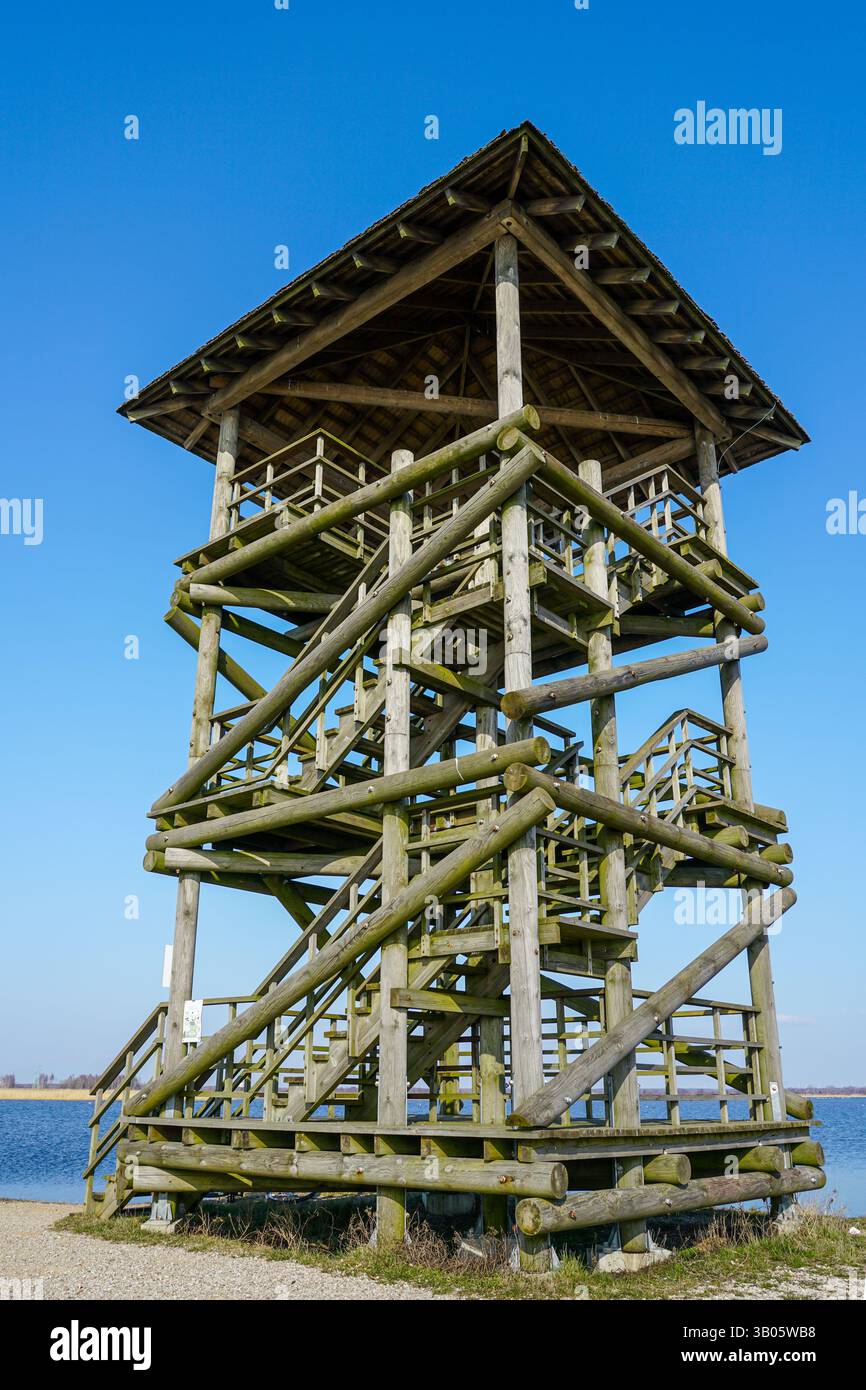 Tour d'observation des oiseaux et de la nature faite de bûches rondes en bois sur le bord d'un lac, vue en perspective rapprochée de bas en haut contre le ciel bleu Banque D'Images