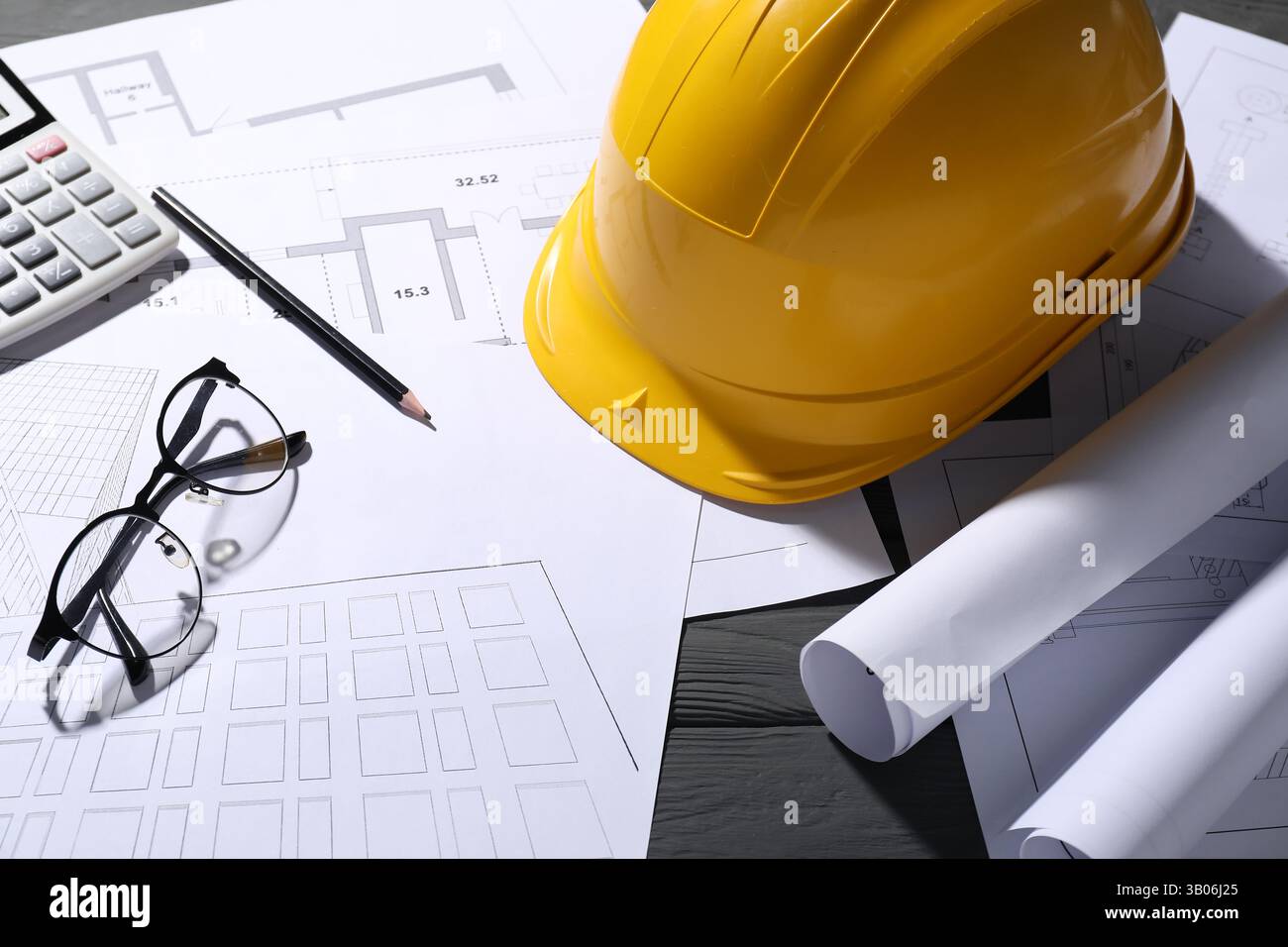 Différents dessins architecturaux, verres, crayon et calculatrice sur table en bois gris, gros plan Banque D'Images