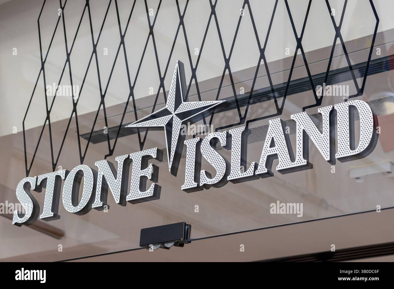 Venise, Italie - 20 avril 2025 : logo StoreFront de la marque de mode Stone Island avec design boussole star Banque D'Images