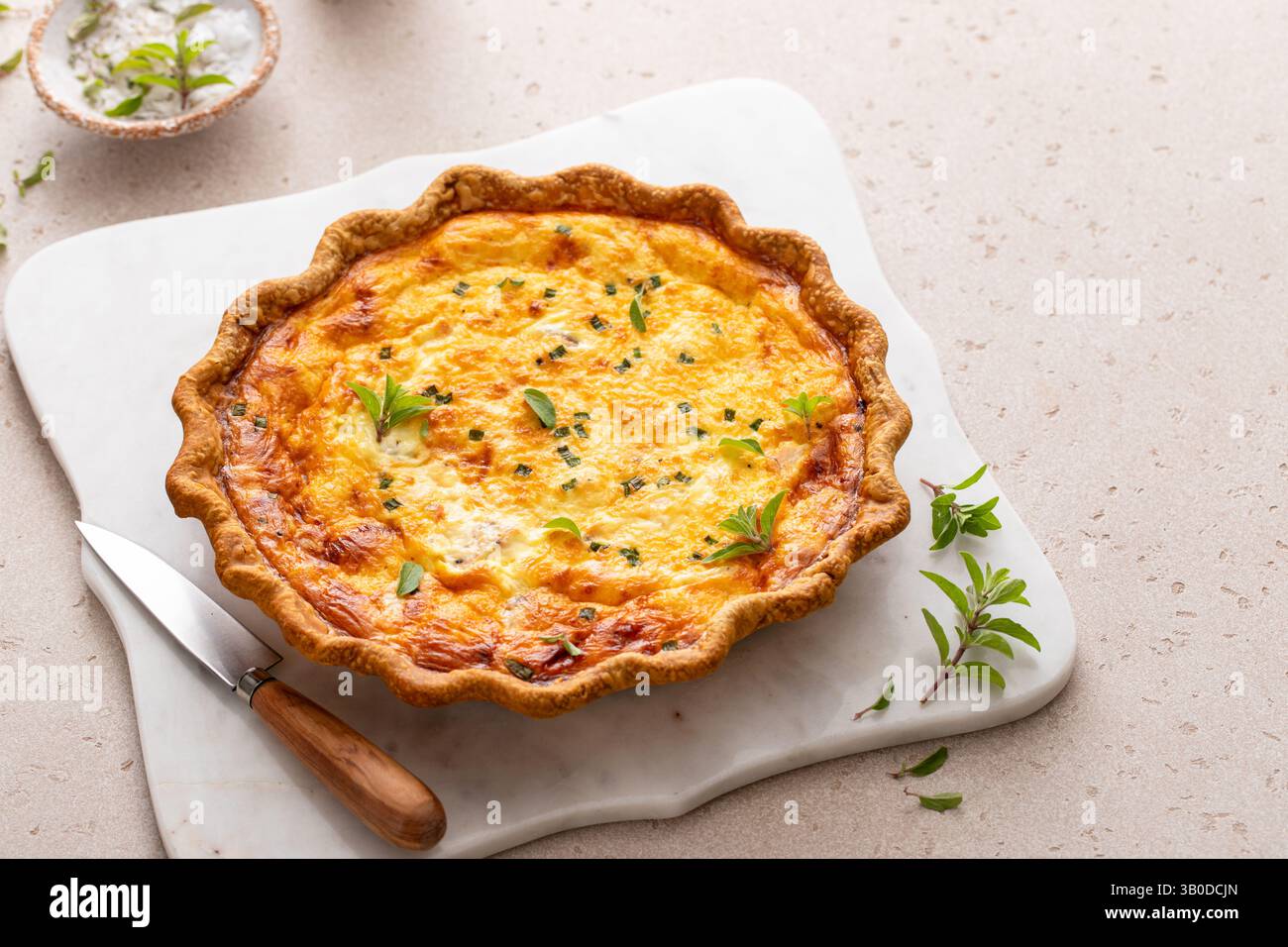 Quiche de saumon fraîchement cuite sur une planche de service, idée de petit déjeuner sain Banque D'Images
