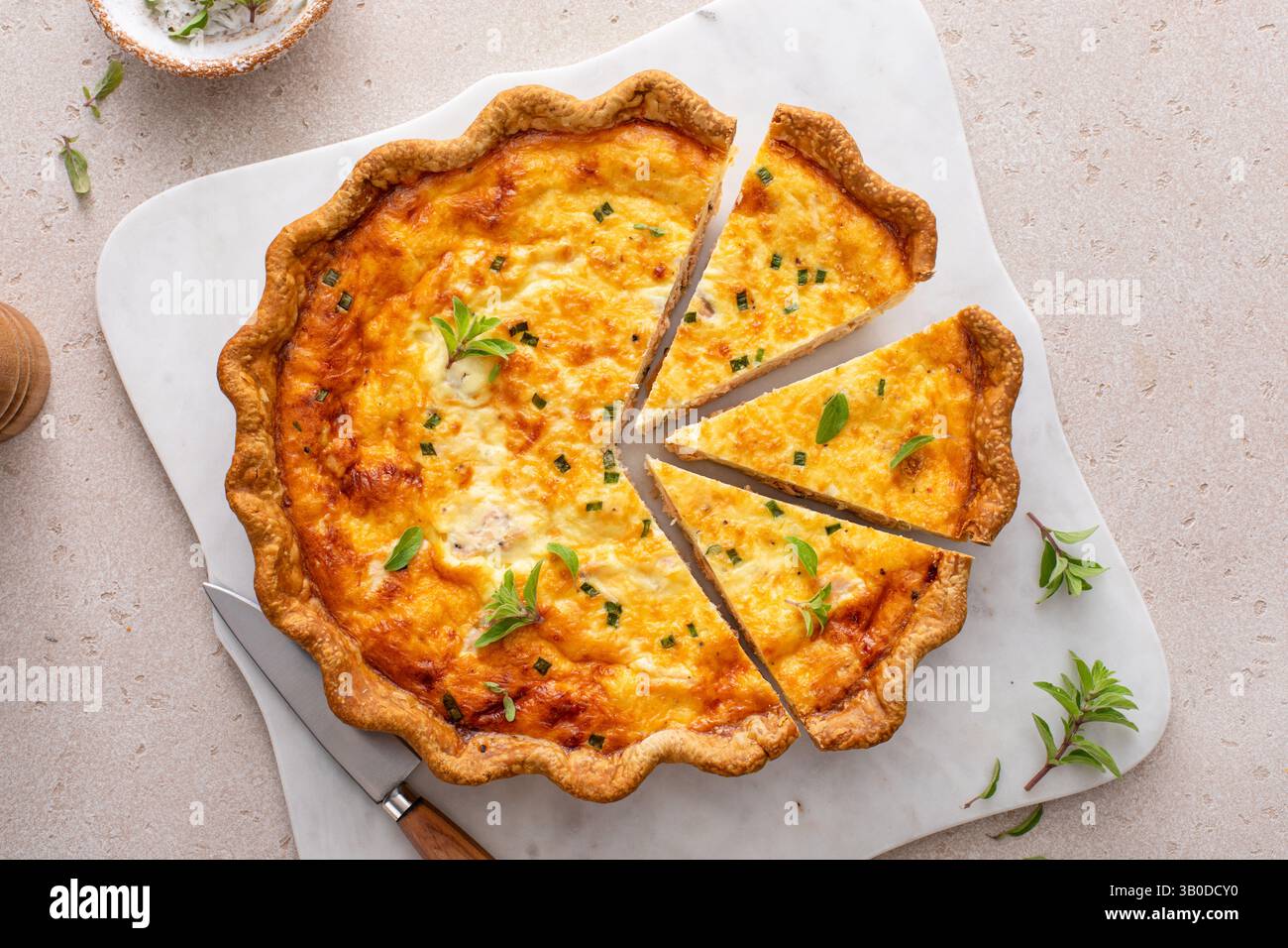 Quiche de saumon fraîchement cuite sur une planche de service, idée de petit déjeuner sain Banque D'Images