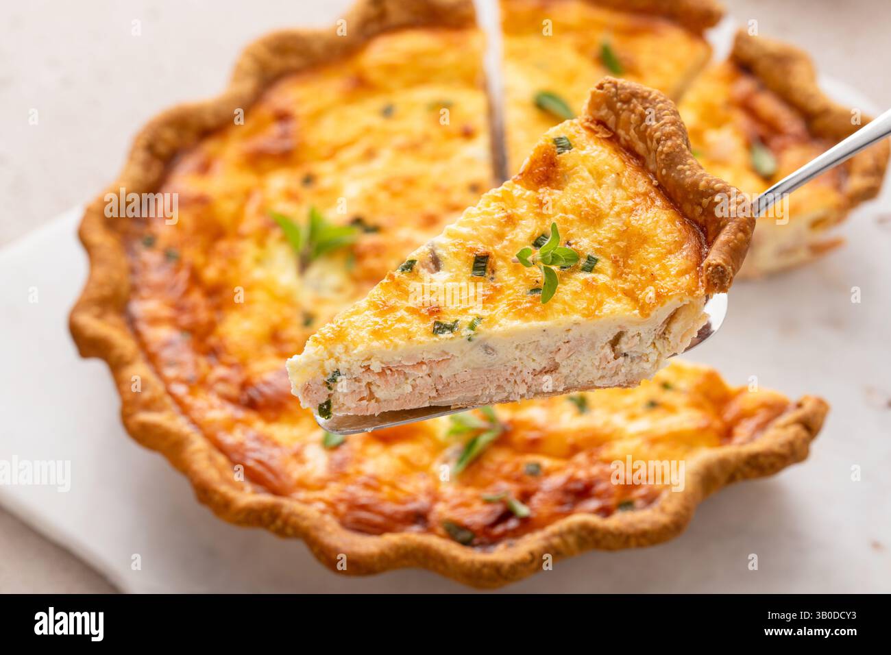 Quiche de saumon fraîchement cuite sur une planche de service, idée de petit déjeuner sain Banque D'Images