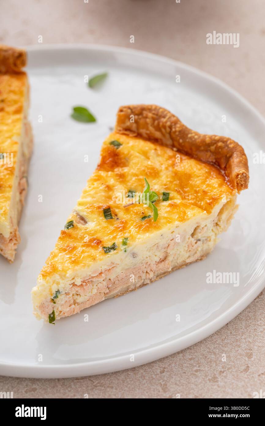 Quiche de saumon fraîchement cuite sur une planche de service, idée de petit déjeuner sain Banque D'Images