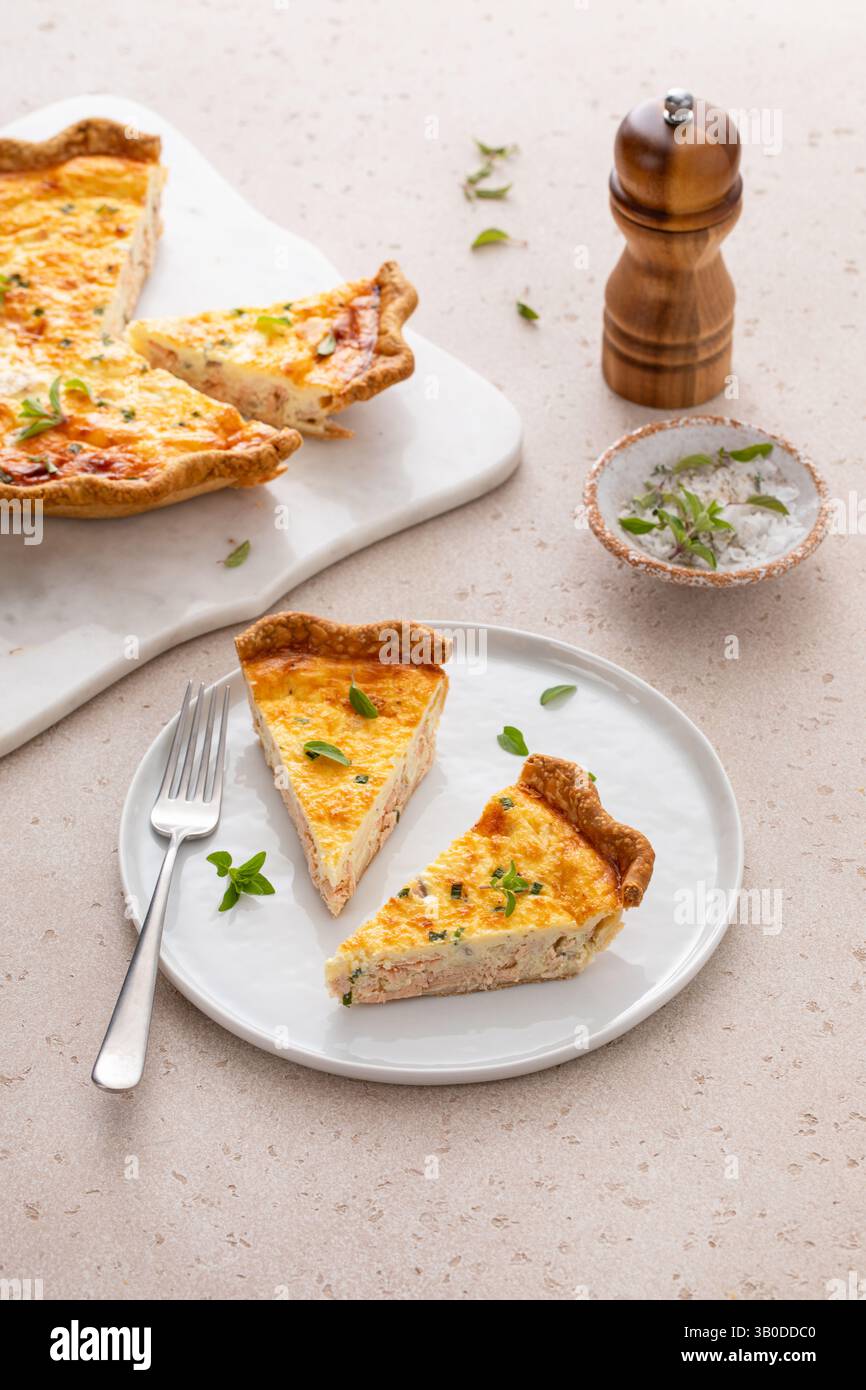 Quiche de saumon fraîchement cuite sur une planche de service, idée de petit déjeuner sain Banque D'Images