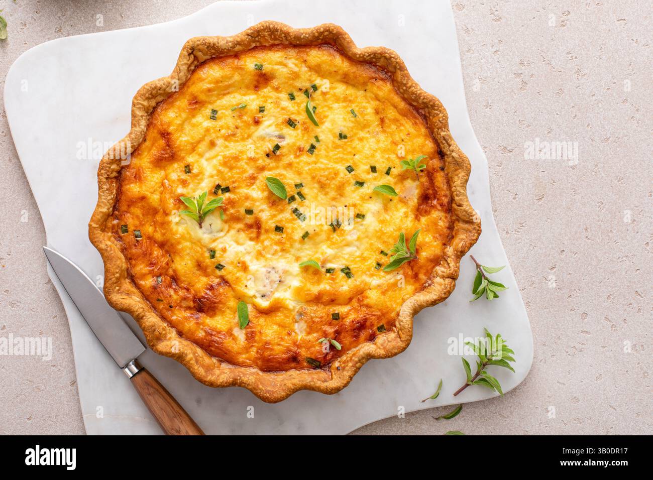 Quiche au saumon et au fromage fraîchement cuite sur une planche de service, idée de petit déjeuner sain Banque D'Images