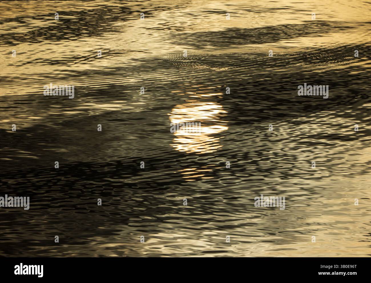 Soleil noyant : reflet abstrait dans le lac au lever du soleil Banque D'Images