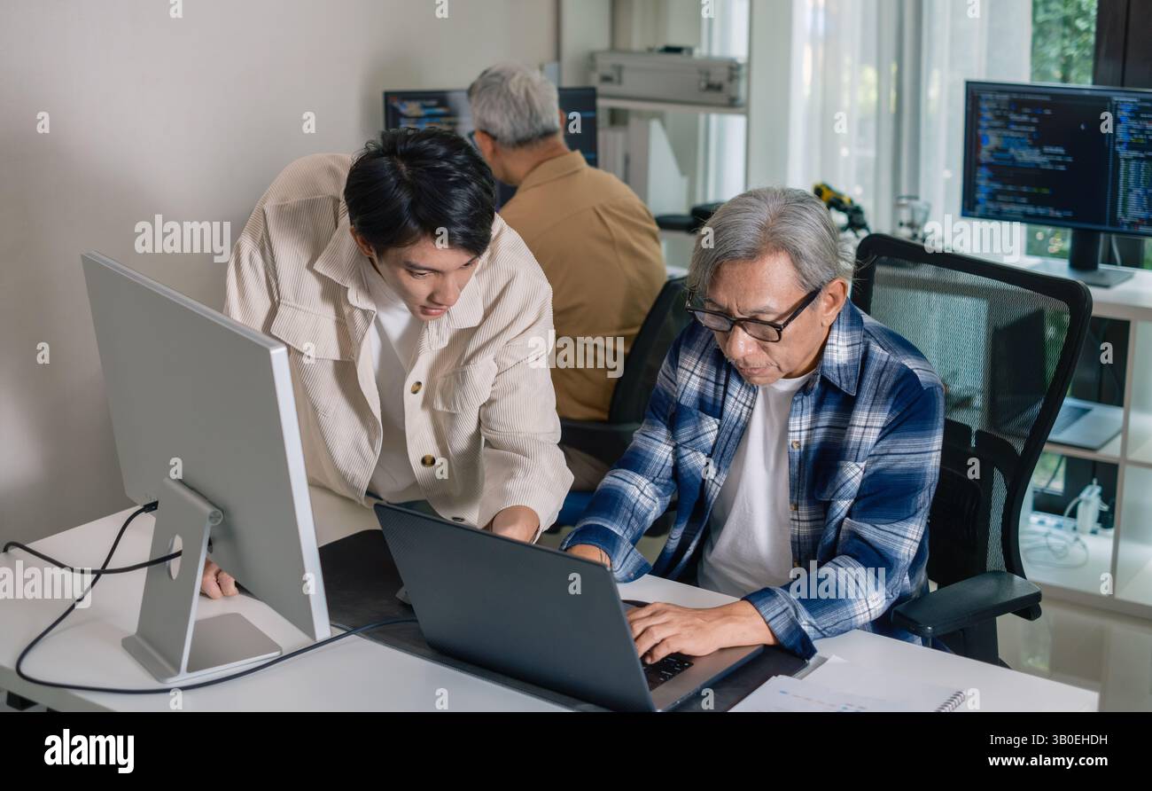 Groupe de senior asiatique dans un développement logiciel collaboratif analysant des organigrammes lors d'une formation bootcamp Banque D'Images