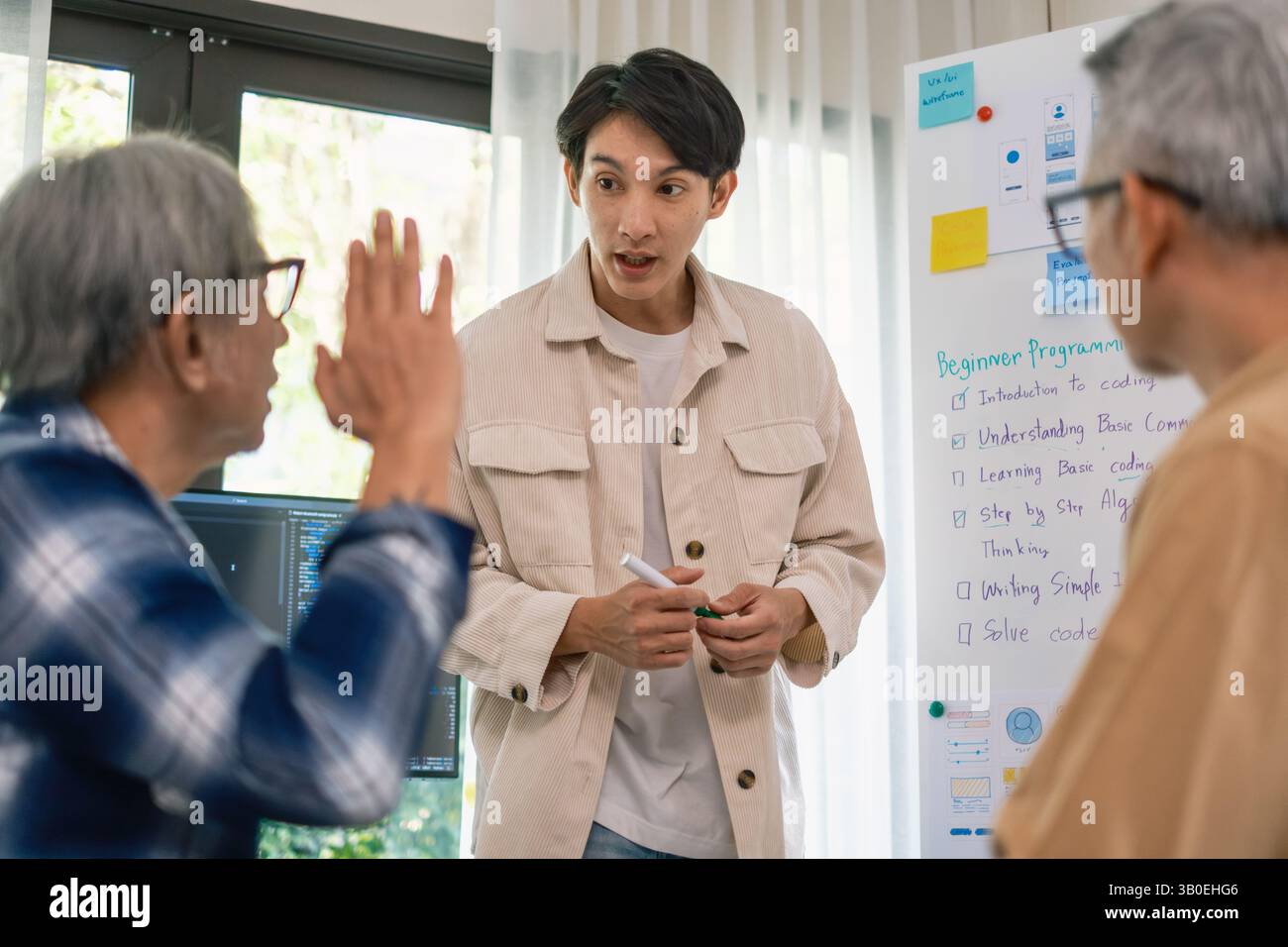 Équipe asiatique senior bootcamp demandant et apprenant la programmation avec formation logicielle et collaboration avec tableau blanc Banque D'Images