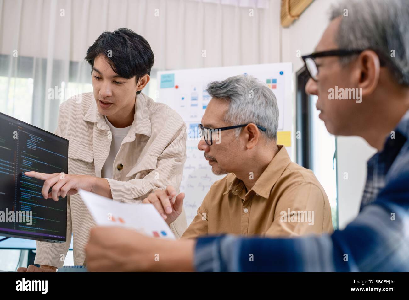 Groupe de senior asiatique dans un développement logiciel collaboratif analysant des organigrammes lors d'une formation bootcamp Banque D'Images