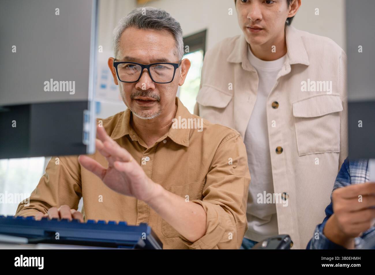 Équipe asiatique senior bootcamp demandant et apprenant la programmation avec formation logicielle et collaboration avec tableau blanc Banque D'Images