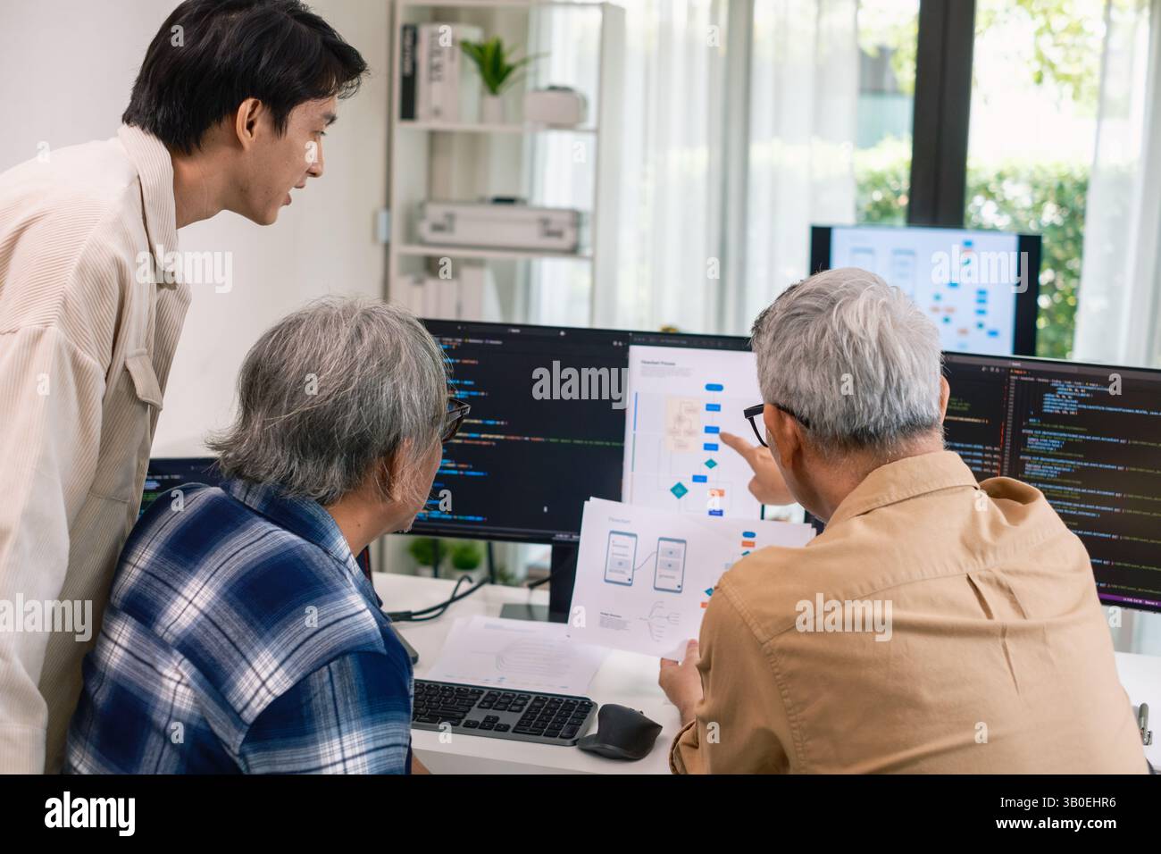 Groupe de senior asiatique dans un développement logiciel collaboratif analysant des organigrammes lors d'une formation bootcamp Banque D'Images