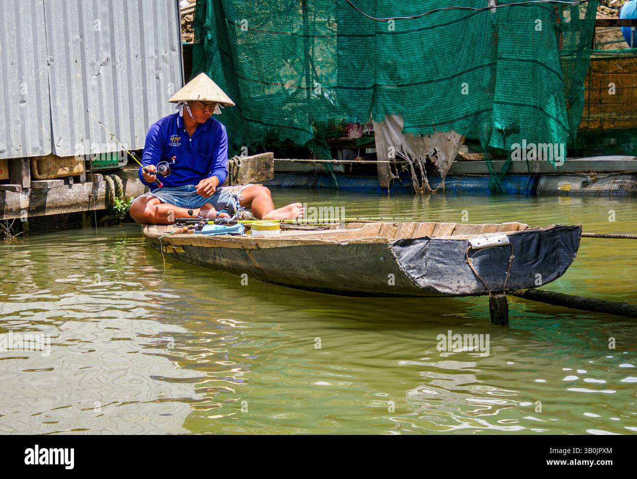 Un pêcheur à côté de sa maison flottante sur le fleuve Mékong, Tan Chau, Vietnam Banque D'Images