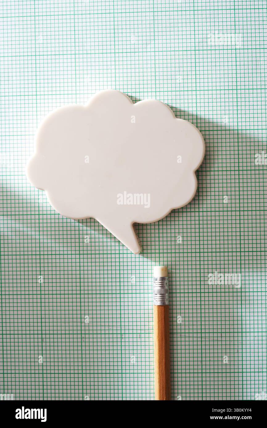 Crayon avec ballon de pensée nuage sur papier millimétré Banque D'Images