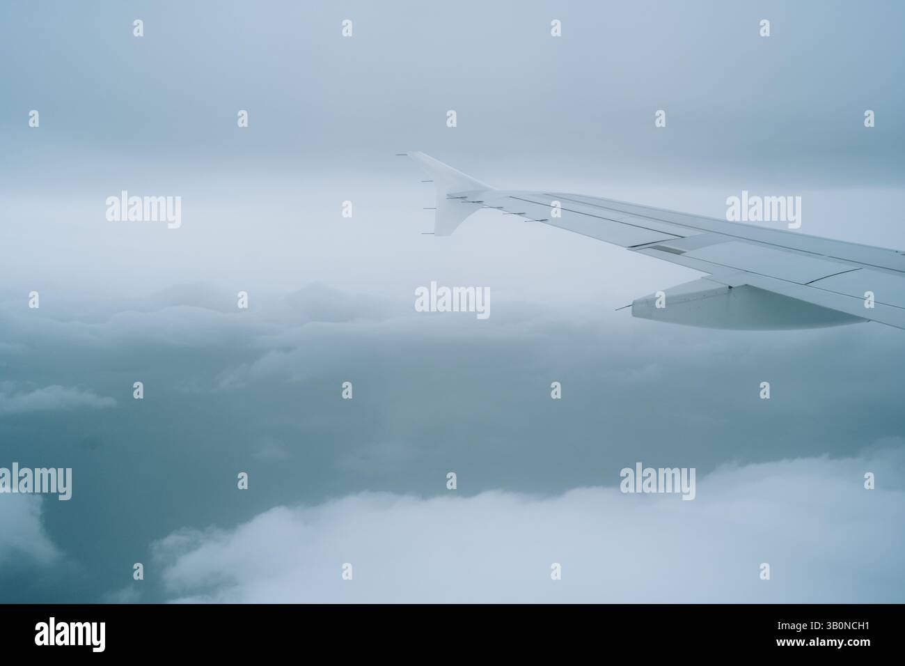 Aile d'avion commercial, survolant un temps nuageux. Point de vue de la fenêtre passager, pas de personnes. Banque D'Images