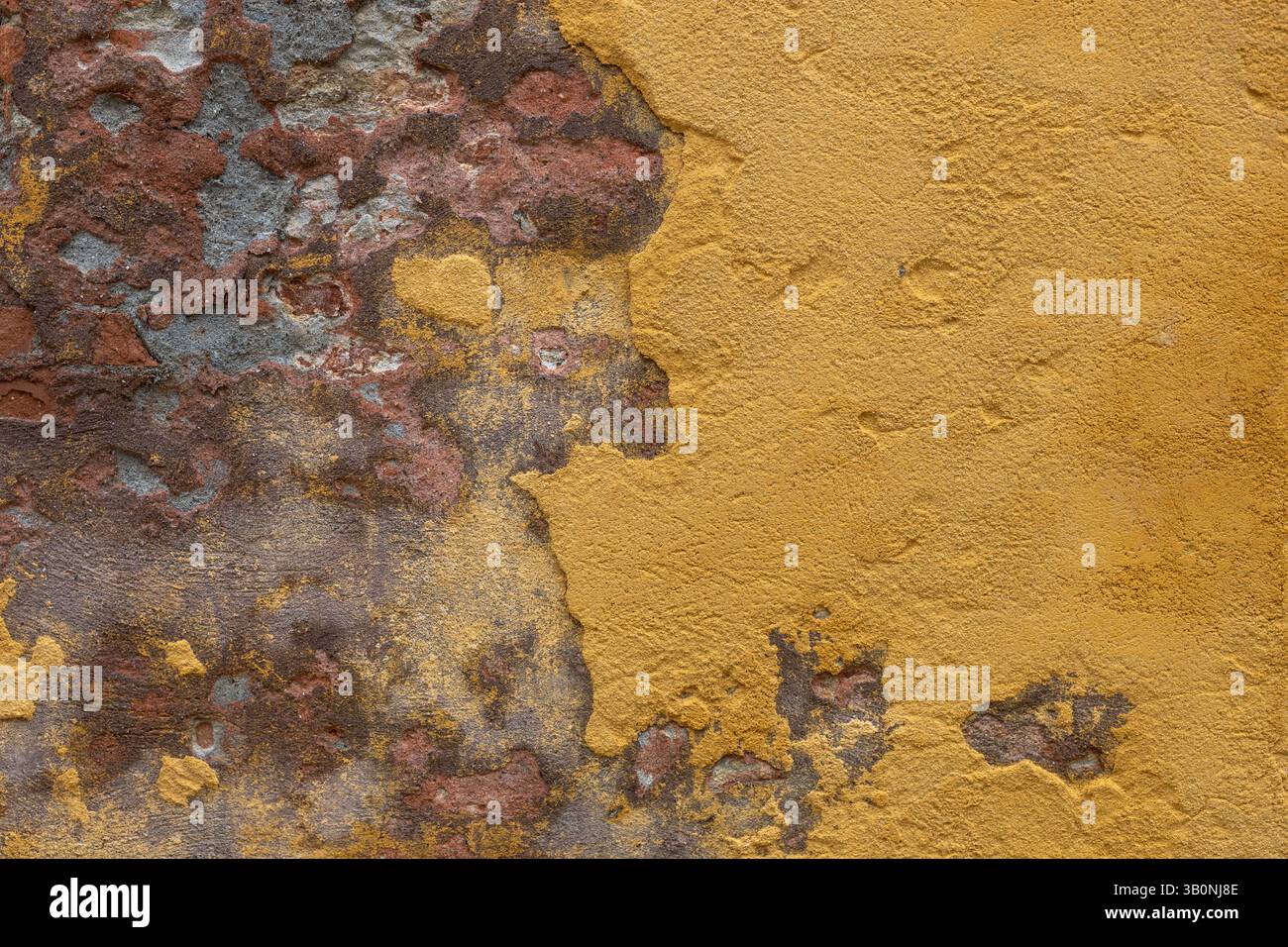 Mur en plâtre jaune vieilli avec des fissures Banque D'Images