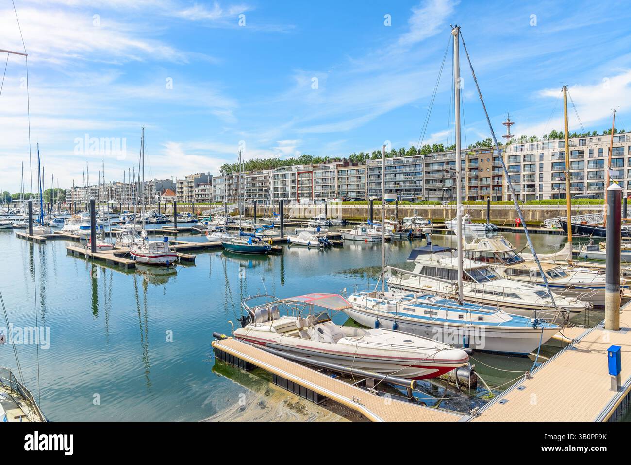 Bateaux amarrés aux jetées dans une marina bordée d'immeubles d'appartements modernes Banque D'Images