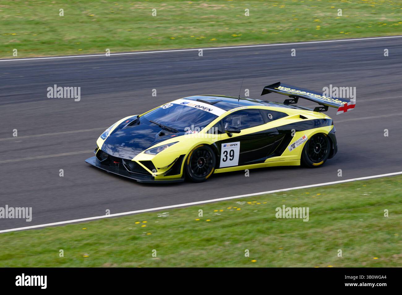 Craig Dolby en route vers une victoire dominante dans sa voiture de course jaune et noire Lamborghini Gallardo GT au Castle Combe Howards Day Race Meeting. Banque D'Images