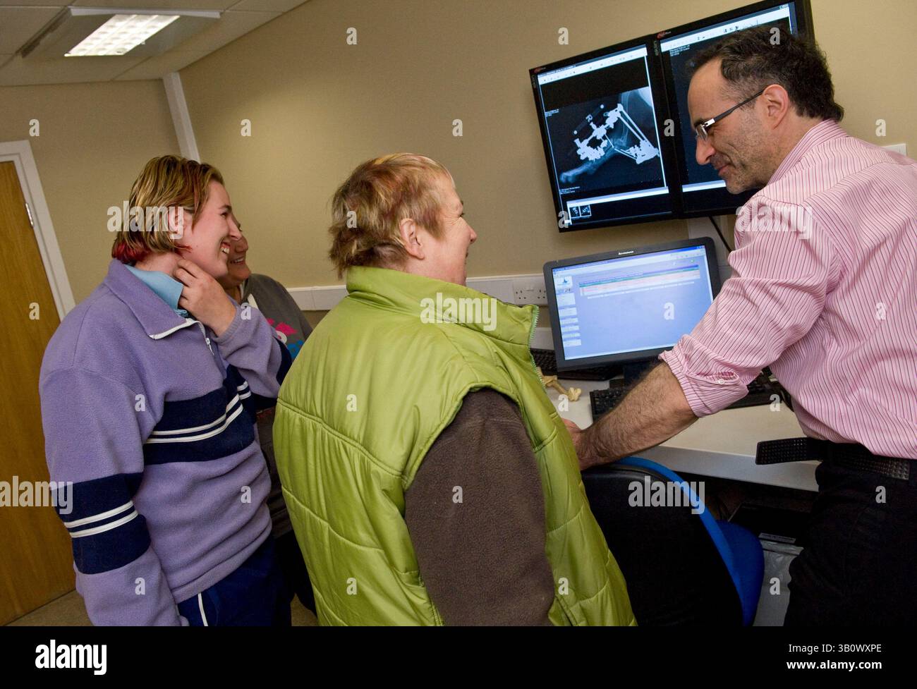 14 décembre 2010 - Eashing, Surrey, Royaume-Uni - Noel en consultation avec les propriétaires de Peggy et radiographie de l'avant-bras de Peggy montrant le fixateur et la correction. Presque tous les autres vétérinaires ne tenteraient pas une correction aussi violente de ne pas mentionner les dépenses, mais amputent sa jambe à la place. Dans un tel cas, les dépenses sont élevées bien dans les plusieurs milliers de livres. Noel agite ses propres coûts et paie partiellement pour les pièces. Les propriétaires paient une contribution pour les pièces. Noel Fitzpatrick est un chirurgien vétérinaire pionnier, un soi-disant Bionic Vet sa pratique vétérinaire de plusieurs millions de livres sterling est à Eashing, S. Banque D'Images