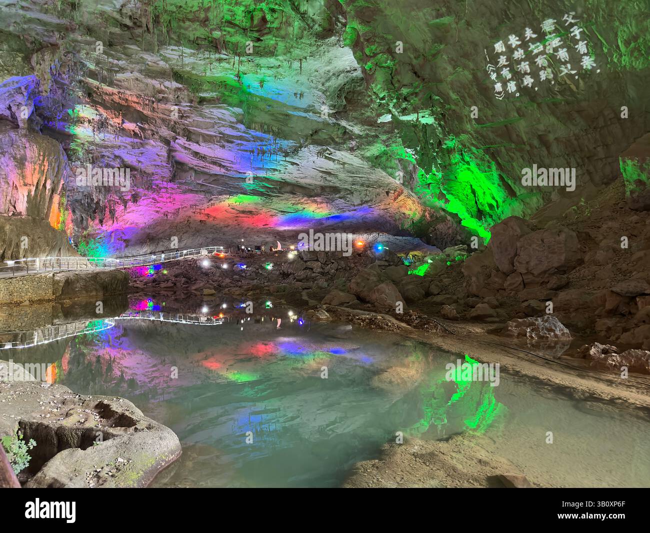 Une magnifique grotte colorée avec de l'eau éclairée et des reflets lumineux vibrants. Banque D'Images