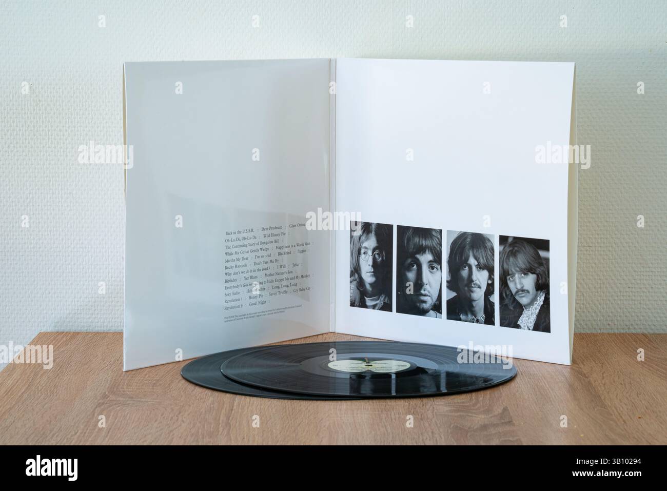 Couverture intérieure du légendaire album White du célèbre groupe rock The Beatles avec deux disques sur une table en bois. Banque D'Images