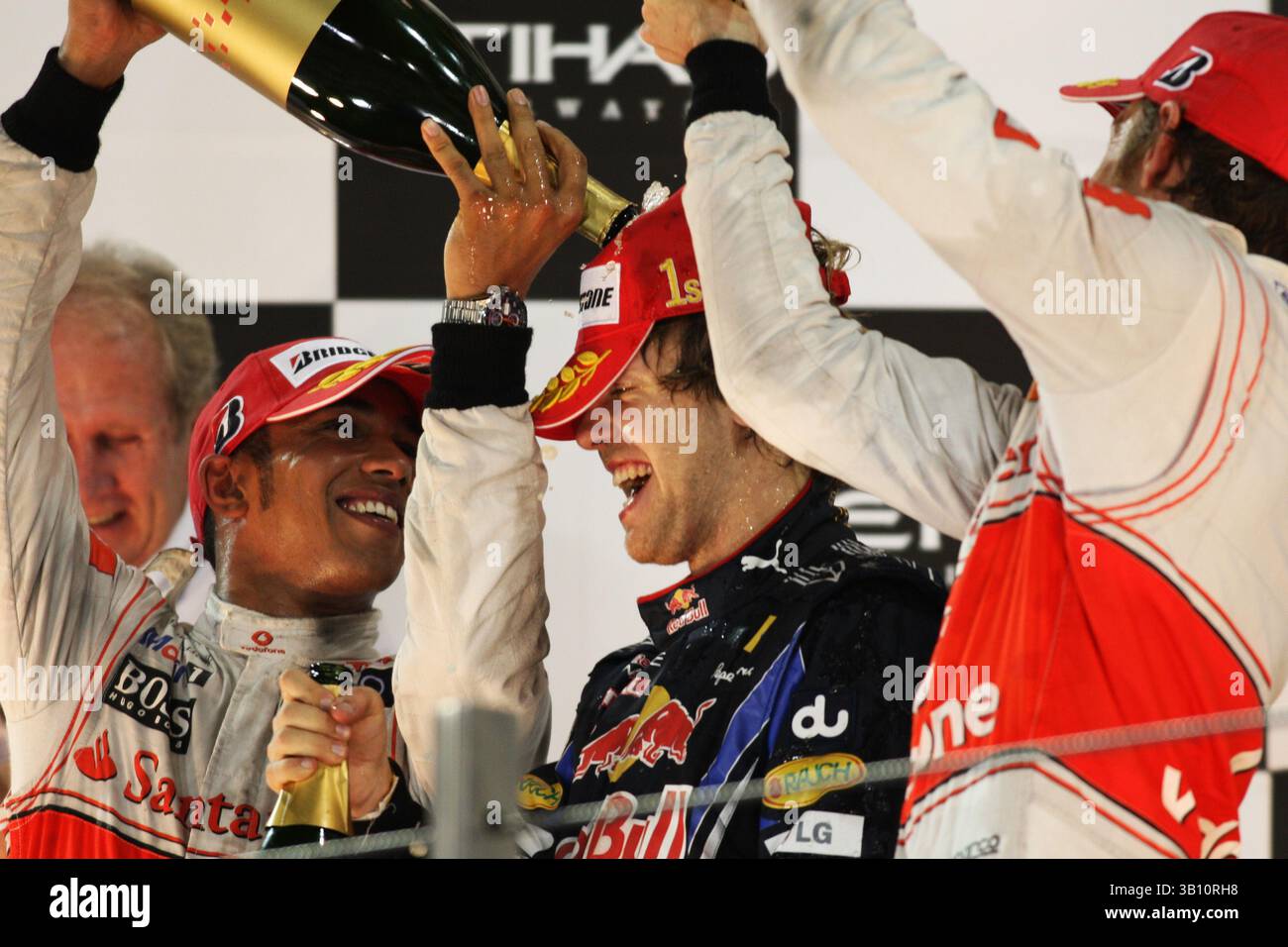 14 novembre 2010 - Abu Dhabi, Emirats Arabes Unis - LEWIS HAMILTON (GBR) McLaren, SEBASTIAN VETTEL (GER) Red Bull Racing et JENSON BUTTON (GBR) McLaren se réjouissent sur le podium après que Vettel ait remporté le Championnat du monde de formule 1, Rd 19, Grand Prix d'Abu Dhabi sur le circuit de Yas Marina. (Crédit : © Sutton Motorsports/ZUMApress.com) Banque D'Images