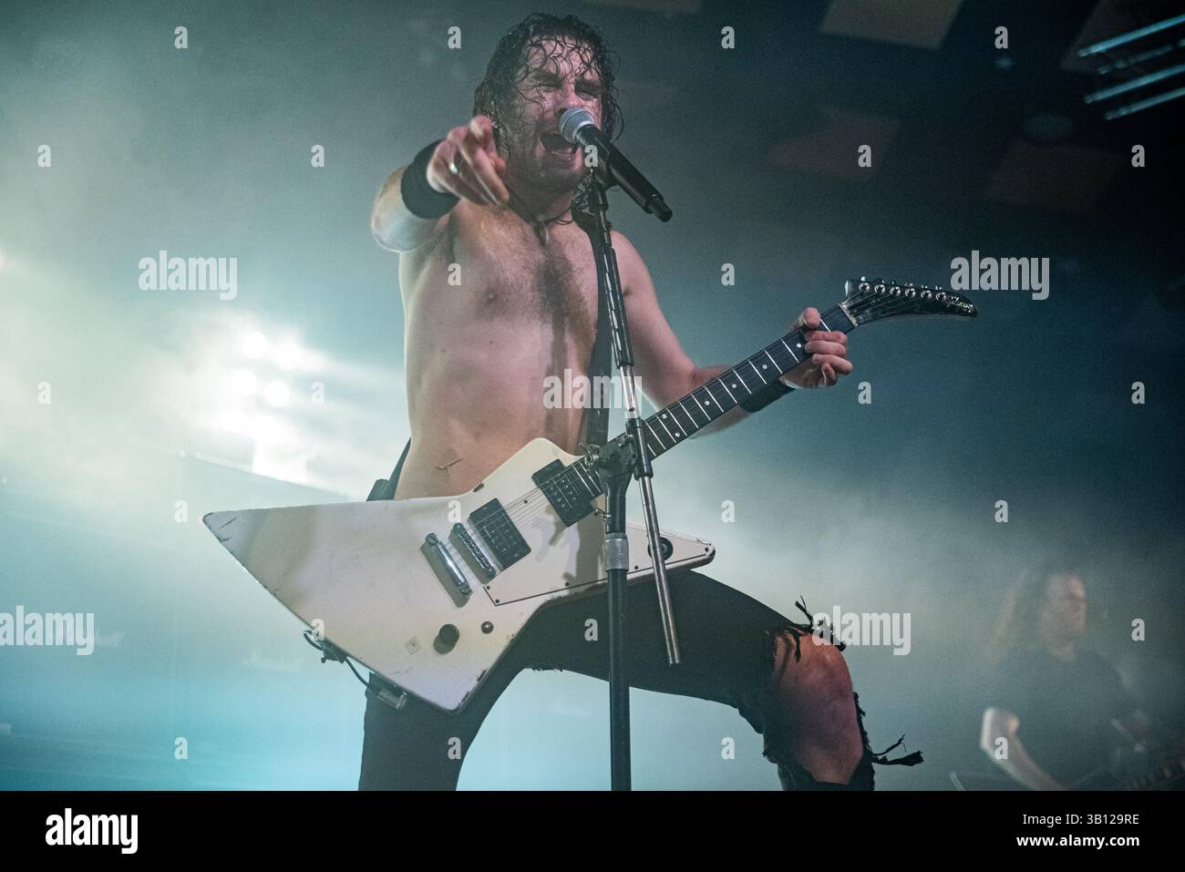 Joel O'Keeffe du rock australien Bad Airbourne se produisant en direct sur scène avec une guitare Flying V, pointant vers la foule Banque D'Images
