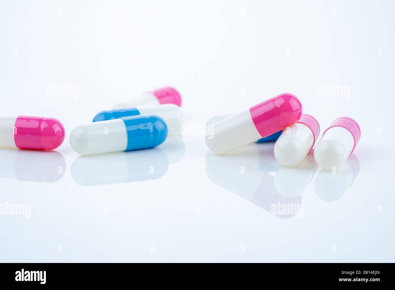 Les pilules de capsule bleues et roses se propagent sur fond blanc, présentant les produits pharmaceutiques, les concepts de soins de santé et le rôle de la médecine de prescription Banque D'Images