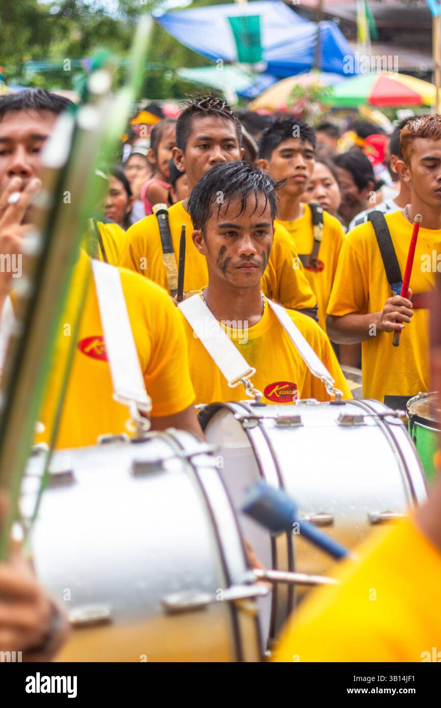 Un adolescent philippin portant une chemise jaune joue de la grosse caisse avec une fanfare pendant le Festival ATI-ATI d'Ibajay à Aklan en l'honneur du Sto Niño Banque D'Images