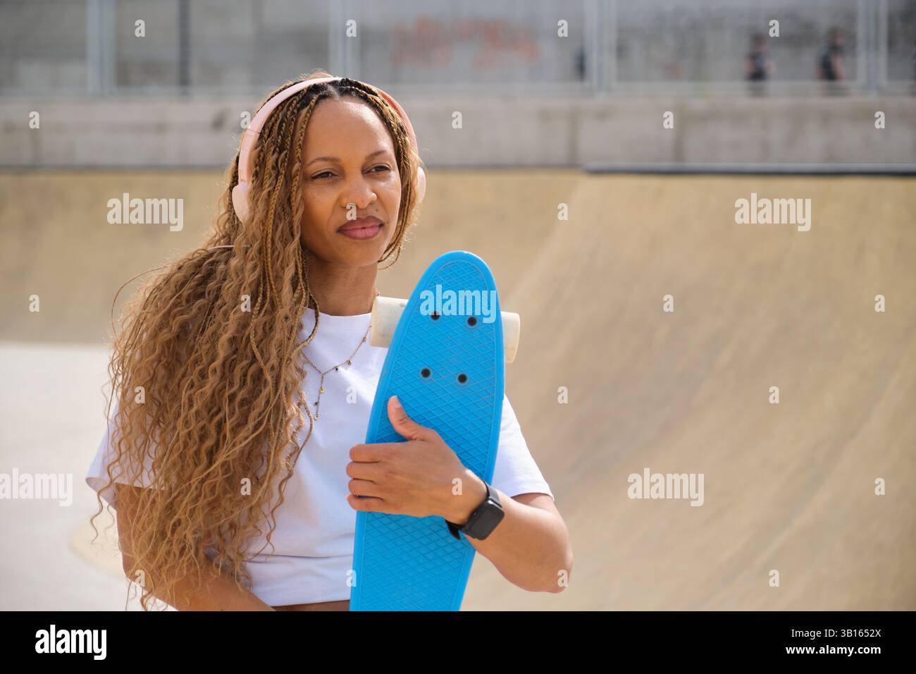 Femme élégante écoutant de la musique et tenant un tableau bleu penny Banque D'Images