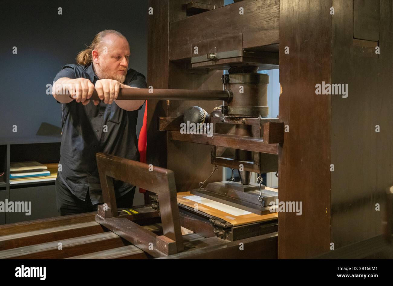(250425) -- MAYENCE, 25 avril 2025 (Xinhua) -- Un membre du personnel du Musée Gutenberg présente la technique d'impression Gutenberg à Mayence, en Allemagne, le 21 mars 2025. Le comté de Yingshan, dans la province chinoise du Hubei, abrite Bi Sheng, qui a inventé la technique d'impression de type argile mobile au XIe siècle. Son invention, une révolution majeure dans l'histoire de l'imprimerie, peut maintenant être expérimentée dans le Bi Sheng Memorial Hall du comté. À des milliers de kilomètres de là, à Mayence, en Allemagne, les visiteurs du musée Gutenberg ont également rencontré un sentiment similaire d'innovation historique. Le musée a été créé en 1900 pour commem Banque D'Images