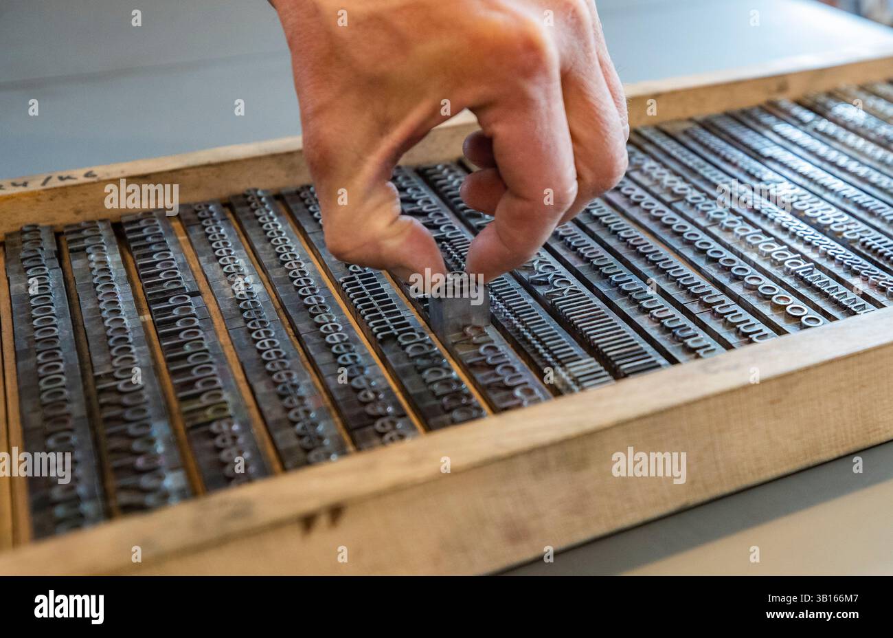 (250425) -- MAYENCE, 25 avril 2025 (Xinhua) -- Christoph Suender, directeur d'atelier d'imprimerie du Musée Gutenberg, présente les clichés d'imprimerie mobiles métalliques à Mayence, en Allemagne, le 21 mars 2025. Le comté de Yingshan, dans la province chinoise du Hubei, abrite Bi Sheng, qui a inventé la technique d'impression de type argile mobile au XIe siècle. Son invention, une révolution majeure dans l'histoire de l'imprimerie, peut maintenant être expérimentée dans le Bi Sheng Memorial Hall du comté. À des milliers de kilomètres de là, à Mayence, en Allemagne, les visiteurs du musée Gutenberg ont également rencontré un sentiment similaire d'innovation historique. Le m Banque D'Images