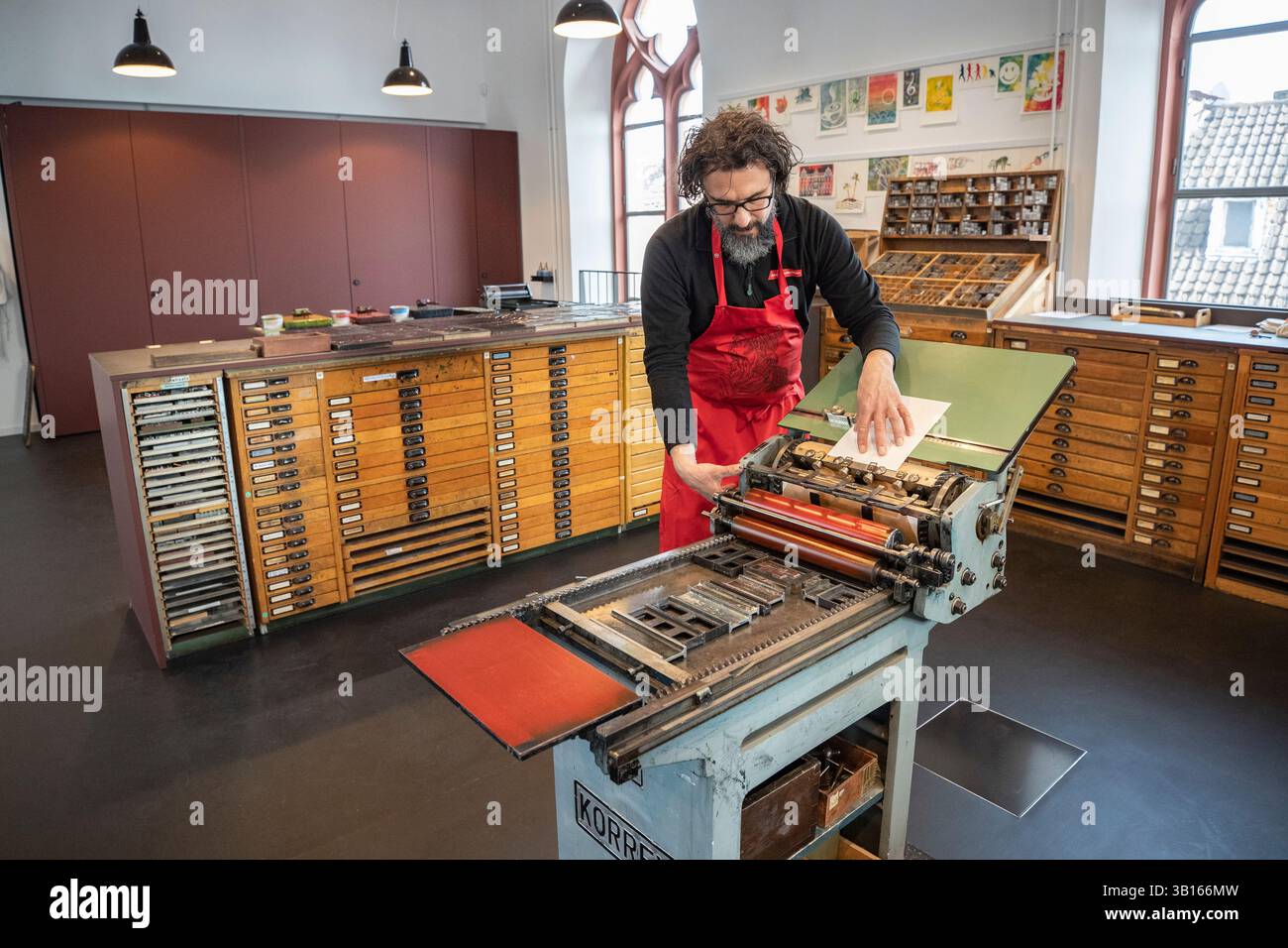 (250425) -- MAYENCE, 25 avril 2025 (Xinhua) -- Christoph Suender, directeur d'atelier d'imprimerie du Musée Gutenberg, présente la technique d'impression de caractères mobiles métalliques à Mayence, en Allemagne, le 21 mars 2025. Le comté de Yingshan, dans la province chinoise du Hubei, abrite Bi Sheng, qui a inventé la technique d'impression de type argile mobile au XIe siècle. Son invention, une révolution majeure dans l'histoire de l'imprimerie, peut maintenant être expérimentée dans le Bi Sheng Memorial Hall du comté. À des milliers de kilomètres de là, à Mayence, en Allemagne, les visiteurs du musée Gutenberg ont également rencontré un sentiment similaire d'innovation historique. Th Banque D'Images