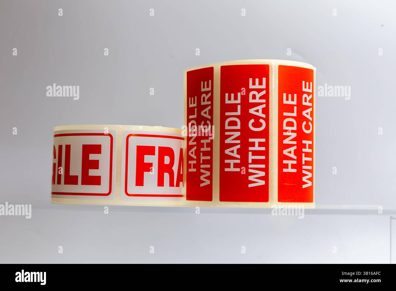 Poignée fragile avec rouleau d'autocollant de soin sur un fond blanc. Banque D'Images