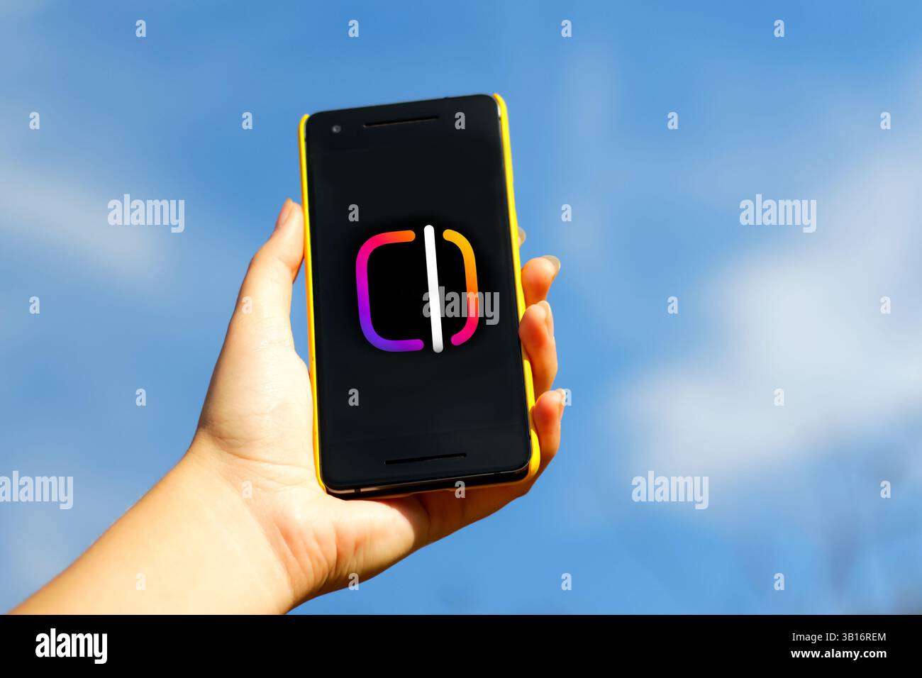 Personne tenant un smartphone avec l'application Instagram ouverte, entourée d'éléments de montage vidéo. création de bobines, modifications et numérique sur le thème bleu Banque D'Images