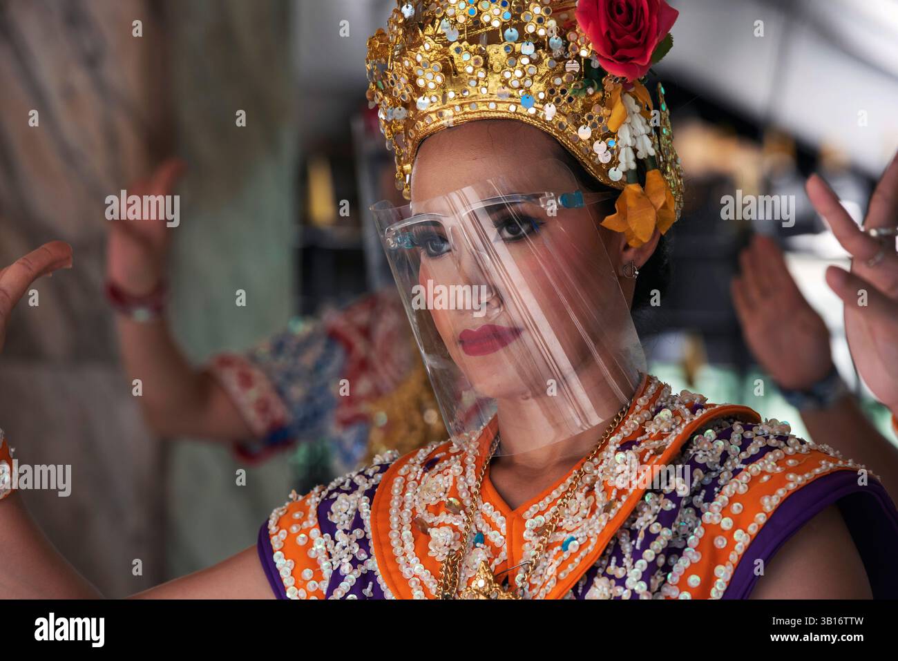Les danseurs de cérémonie du sanctuaire Erawan de Bangkok portent des visières en plastique pour se protéger contre Covid 19 Banque D'Images