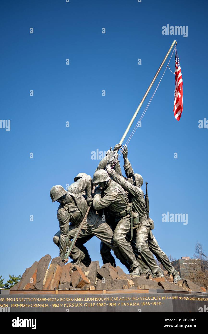 ARLINGTON, États-Unis — le Mémorial de guerre du corps des Marines (également connu sous le nom de Mémorial Iwo Jima) est dessiné contre un soleil brillant et un ciel bleu clair à Arlington, en Virginie. L'emblématique statue en bronze représente six Marines levant le drapeau américain sur le mont Suribachi pendant la bataille d'Iwo Jima pendant la seconde Guerre mondiale. Inauguré en 1954, le mémorial a été sculpté par Felix de Weldon et basé sur la célèbre photographie de Joe Rosenthal. Banque D'Images