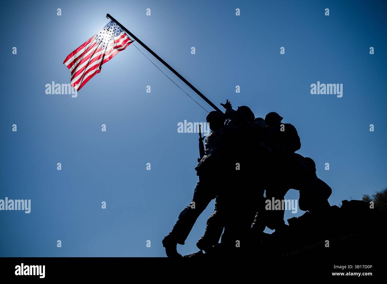 ARLINGTON, États-Unis — le Mémorial de guerre du corps des Marines (également connu sous le nom de Mémorial Iwo Jima) est dessiné contre un soleil brillant et un ciel bleu clair à Arlington, en Virginie. L'emblématique statue en bronze représente six Marines levant le drapeau américain sur le mont Suribachi pendant la bataille d'Iwo Jima pendant la seconde Guerre mondiale. Inauguré en 1954, le mémorial a été sculpté par Felix de Weldon et basé sur la célèbre photographie de Joe Rosenthal. Banque D'Images