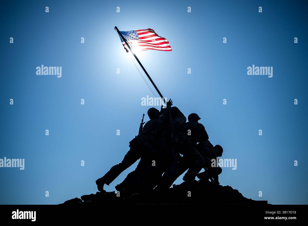 ARLINGTON, États-Unis — le Mémorial de guerre du corps des Marines (également connu sous le nom de Mémorial Iwo Jima) est dessiné contre un soleil brillant et un ciel bleu clair à Arlington, en Virginie. L'emblématique statue en bronze représente six Marines levant le drapeau américain sur le mont Suribachi pendant la bataille d'Iwo Jima pendant la seconde Guerre mondiale. Inauguré en 1954, le mémorial a été sculpté par Felix de Weldon et basé sur la célèbre photographie de Joe Rosenthal. Banque D'Images