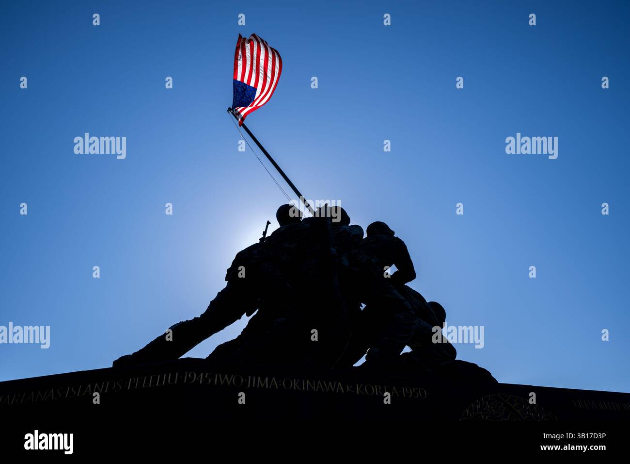 ARLINGTON, États-Unis — le Mémorial de guerre du corps des Marines (également connu sous le nom de Mémorial Iwo Jima) est dessiné contre un soleil brillant et un ciel bleu clair à Arlington, en Virginie. L'emblématique statue en bronze représente six Marines levant le drapeau américain sur le mont Suribachi pendant la bataille d'Iwo Jima pendant la seconde Guerre mondiale. Inauguré en 1954, le mémorial a été sculpté par Felix de Weldon et basé sur la célèbre photographie de Joe Rosenthal. Banque D'Images