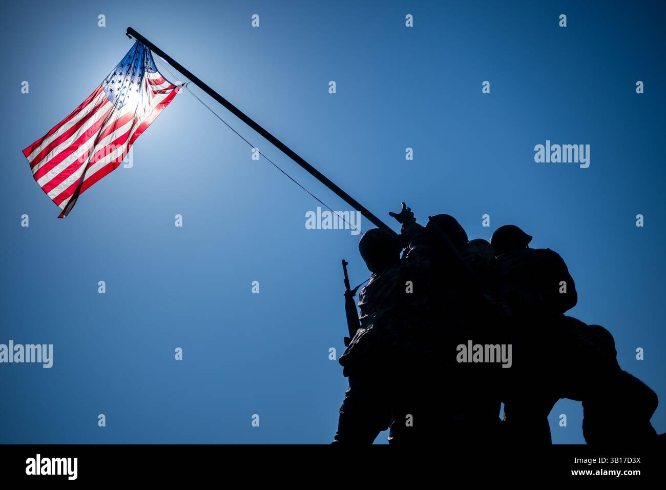 ARLINGTON, États-Unis — le Mémorial de guerre du corps des Marines (également connu sous le nom de Mémorial Iwo Jima) est dessiné contre un soleil brillant et un ciel bleu clair à Arlington, en Virginie. L'emblématique statue en bronze représente six Marines levant le drapeau américain sur le mont Suribachi pendant la bataille d'Iwo Jima pendant la seconde Guerre mondiale. Inauguré en 1954, le mémorial a été sculpté par Felix de Weldon et basé sur la célèbre photographie de Joe Rosenthal. Banque D'Images