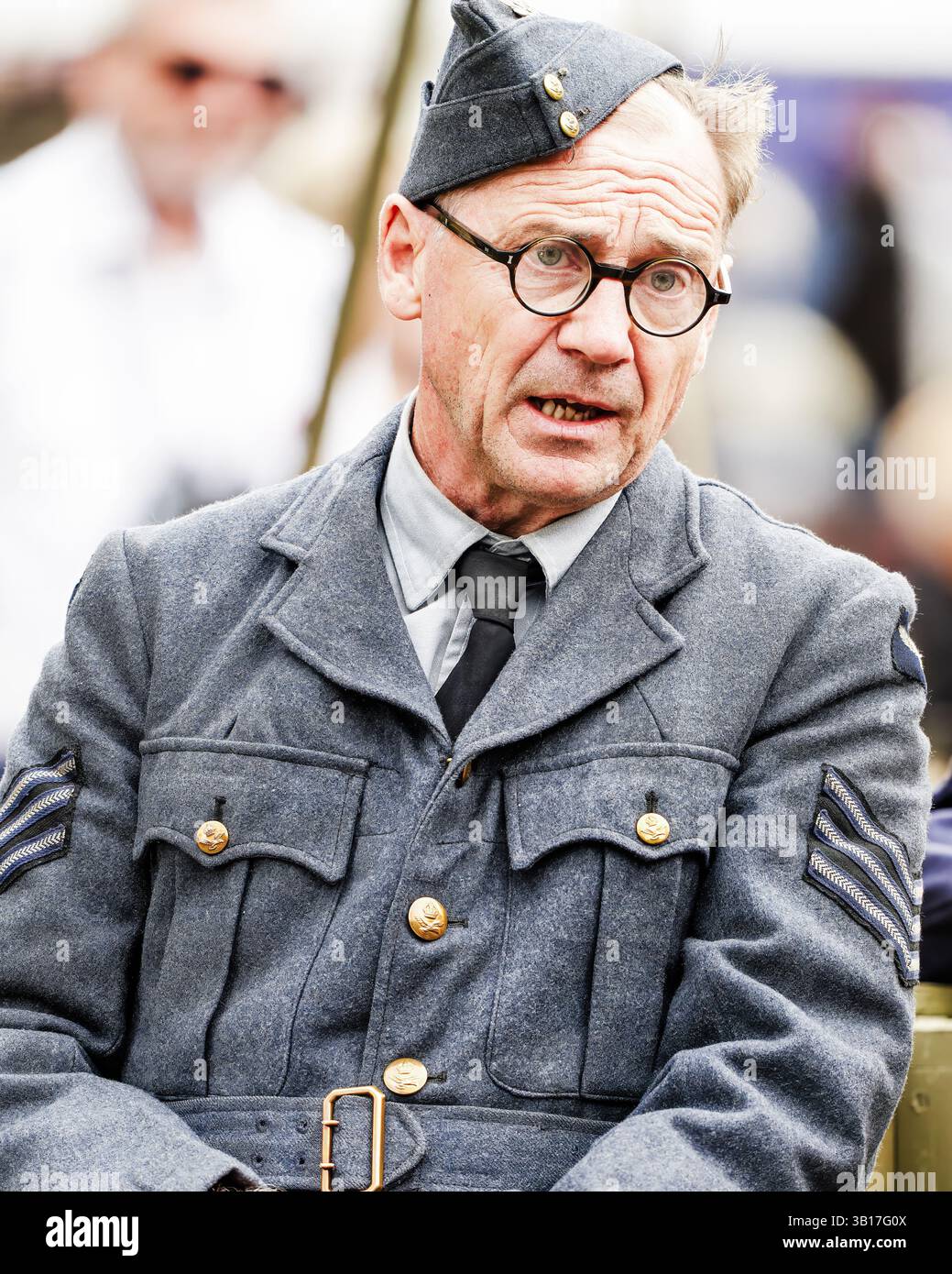 Un homme dans un uniforme vintage de la Royal Air Force, représentant probablement un aviateur de la seconde Guerre mondiale, regarde attentivement devant Duxford, en Angleterre, Banque D'Images